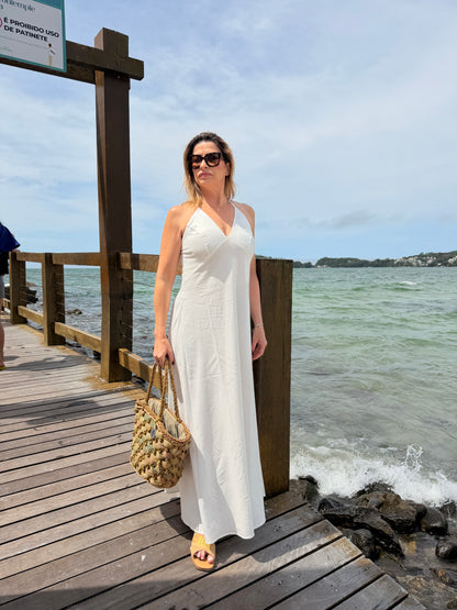 Um vestido longo, fluido e elegante com decote em V e alças finas que se cruzam nas costas com regulagem