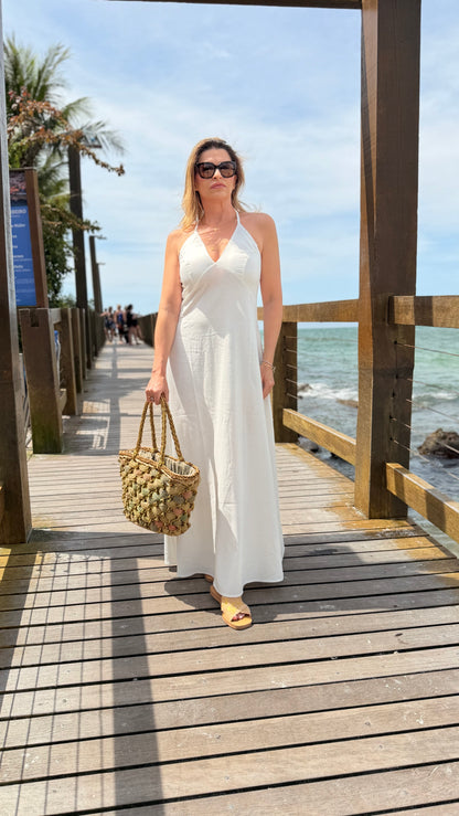 Um vestido longo, fluido e elegante com decote em V e alças finas que se cruzam nas costas com regulagem